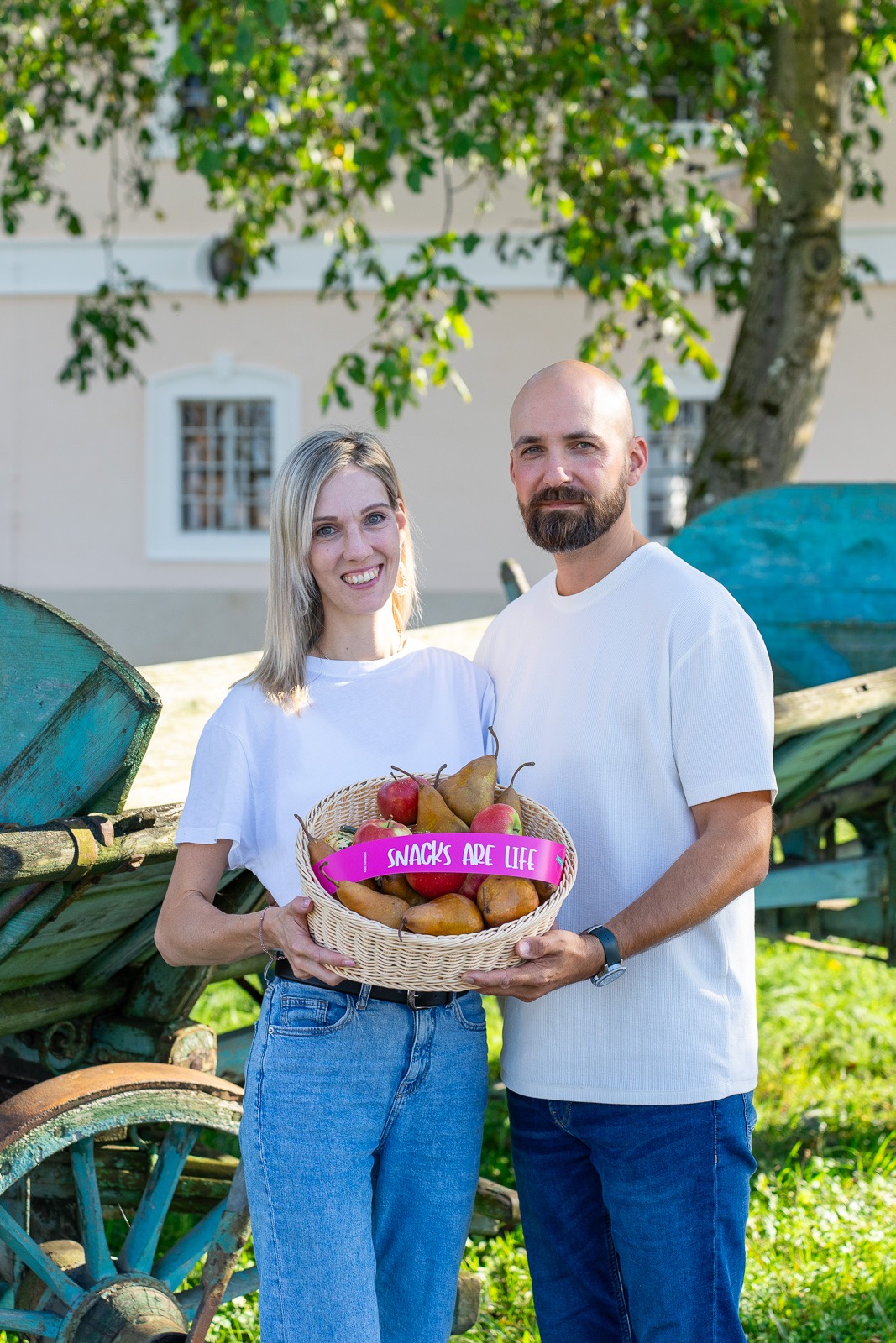 a man and woman holding a basket of fruit